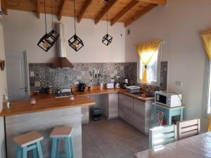 エル・カラファテにあるLo de Pipo tu casa en El Calafateのキッチン(カウンター、スツール付)