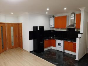 a kitchen with orange and white cabinets and a washer at holiday house in Yerevan