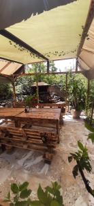 un patio con mesas de madera y una sombrilla grande en holiday house, en Ereván