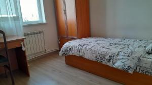 Un dormitorio con una cama y un escritorio y una ventana. en holiday house, en Ereván