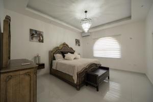 a bedroom with a bed and a chandelier at Summer Shades Villa at Legacy in Montego Bay