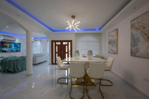 a dining room with a table and white chairs at Summer Shades Villa at Legacy in Montego Bay