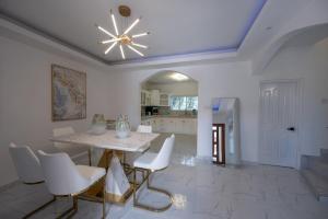 a dining room with a table and white chairs at Summer Shades Villa at Legacy in Montego Bay
