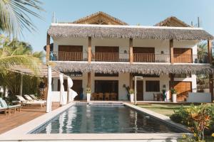 a villa with a swimming pool and a house at Villa Binn Preá in Prea