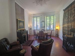 - un salon avec une cheminée, une table et des chaises dans l'établissement Collobrières Centre Appartement, à Collobrières