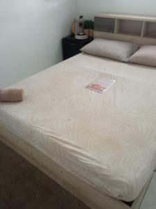 a bed with a book sitting on top of it at Chambre d'hôte in Fort-de-France