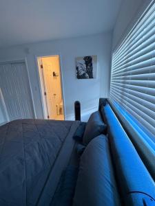 a bedroom with a blue bed with a window with blinds at Family Willy Michel in Opa-locka