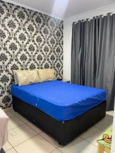 a blue bed in a room with a wall at salaliving 405 in São Vicente