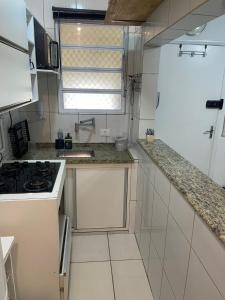 a white kitchen with a sink and a stove at salaliving 405 in São Vicente