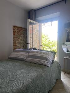 a bed in a bedroom with a large window at Casa Danesi in Monteleone dʼOrvieto