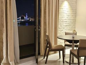 a dining room with a table and chairs and a window at Crown Suites Apart Baku in Baku