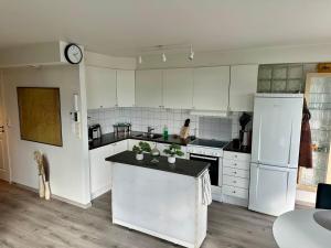 a kitchen with white appliances and a clock on the wall at Heiberg's apartment in Bodø