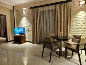 a living room with a table and a television at Crown Suites Apart Baku in Baku