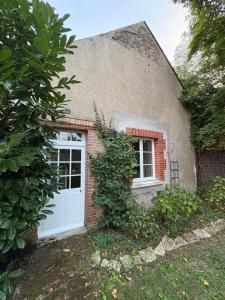 a brick house with a white door and a window at Charmant Cottage in Olivet