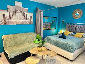 ein blaues Schlafzimmer mit einem Bett und einem Sofa in der Unterkunft Studio - Centre - Gare - wifi in Lorient