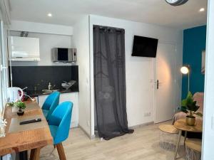 ein Wohnzimmer mit einem Tisch und blauen Stühlen in der Unterkunft Studio - Centre - Gare - wifi in Lorient + 15 Fotos