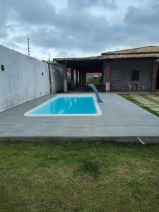una piscina in un cortile accanto a una casa di Casa de praia Atalaia Nova a Barra dos Coqueiros