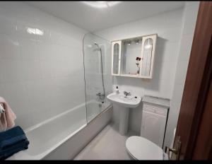 a white bathroom with a sink and a shower at Habitación en A Coruña con baño privado in Visma