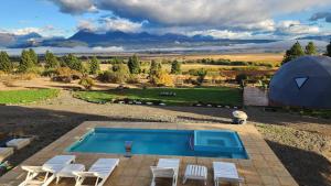 an image of a swimming pool with chairs and a tent at Nawal Glamping - Domos in Trevelín