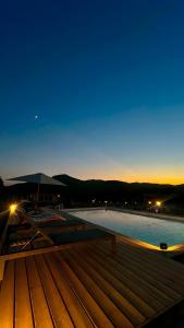 une vue d'une piscine la nuit avec le ciel dans l'établissement Les Chalets De Tesa 3, à Occhiatana