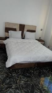 a bedroom with a large bed with white sheets at Spacious and comfortable villa in Marrakesh