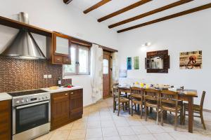 a kitchen with a table and a dining room at Villa Avra by Villa Plus in Asprouliánoi
