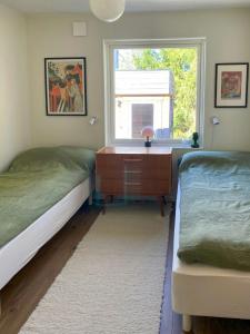 a bedroom with two beds and a desk and a window at Embrace The Island Life And Natural Wilderness in Vätö