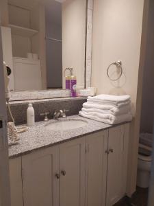 a bathroom with a sink and a mirror and towels at Hermoso Departamento monoambiente, excelente ubicación a 50 mts de Plaza principal in Salta