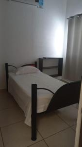 a bedroom with a bed with a black frame and white sheets at Casa Vallarta in Cedro