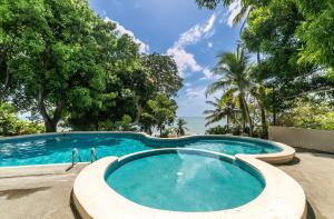 a swimming pool in a resort with trees at Cacao Suites With Pool in Coronado Luxury Club Golf & Beach in Chame