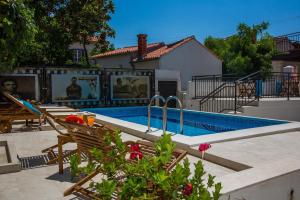 una piscina con due sedie accanto a una casa di Apartments La Bohème a Dubrovnik