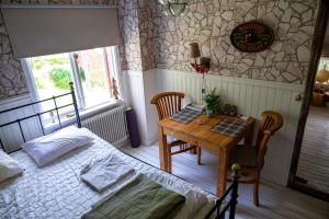 a bedroom with a bed and a table and a clock at Wildlife Appartement - Wilderness Adventures Sweden in Bispgården