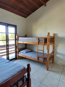 a bedroom with two bunk beds and a window at Casa para Temporada na Morada da Praia em Bertioga SP in Bertioga