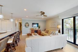 a living room with a white couch and a table at Water's Edge 105 South in Holmes Beach