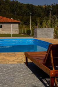 una piscina blu con una panchina accanto di Chácara da Moenda em Joanópolis a Joanópolis