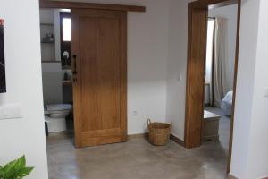 a bathroom with a wooden door and a toilet at Casa Antonio-Tinajo in Tinajo