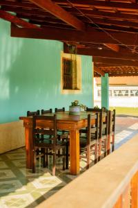 un tavolo da pranzo in legno e sedie in camera di Chácara da Moenda em Joanópolis a Joanópolis