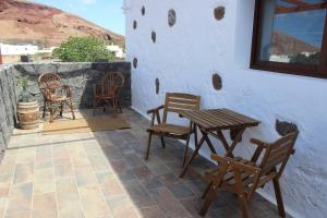 a patio with chairs and a wooden table and chairs at Casa Antonio-Tinajo in Tinajo
