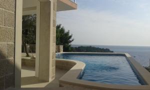 a swimming pool with a view of the ocean at Apartments Odiva in Luštica