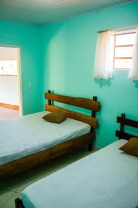 2 letti in una camera con parete blu di Chácara da Moenda em Joanópolis a Joanópolis Altre 34 foto