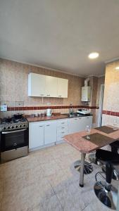 a kitchen with white cabinets and a table in it at Comodo departamento ,Viña del mar cercano al Casino y Playa in Viña del Mar