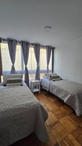 a bedroom with two beds and a window at Comodo departamento ,Viña del mar cercano al Casino y Playa in Viña del Mar