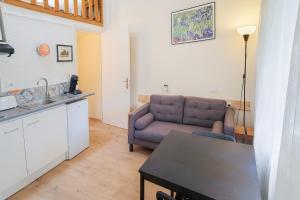 a living room with a couch and a kitchen at Havre Cocon - Clim, TV, Wifi in Bollène