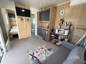a small living room with a couch and a kitchen at Ljubac Harmony Mobilház in Ljubač +6 photos