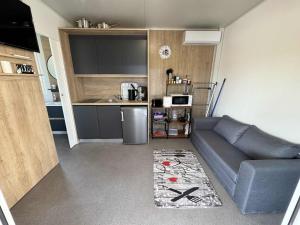 a living room with a couch and a kitchen at Ljubac Harmony Mobilház in Ljubač