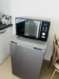 a microwave oven sitting on top of a refrigerator at Royal House Meaux Centre-Ville Disneyland Paris in Meaux