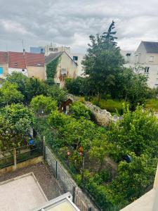 a view of a garden with trees and buildings at Royal House Meaux Centre-Ville Disneyland Paris in Meaux