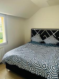 a bedroom with a bed with a black and white comforter at Royal House Meaux Centre-Ville Disneyland Paris in Meaux