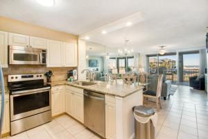 a kitchen with white cabinets and a kitchen with a dining room at Magnolia House at Destin Pointe 203 in Destin