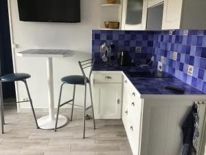 a kitchen with blue tiles on the counter and stools at Fréjus plage B in Fréjus